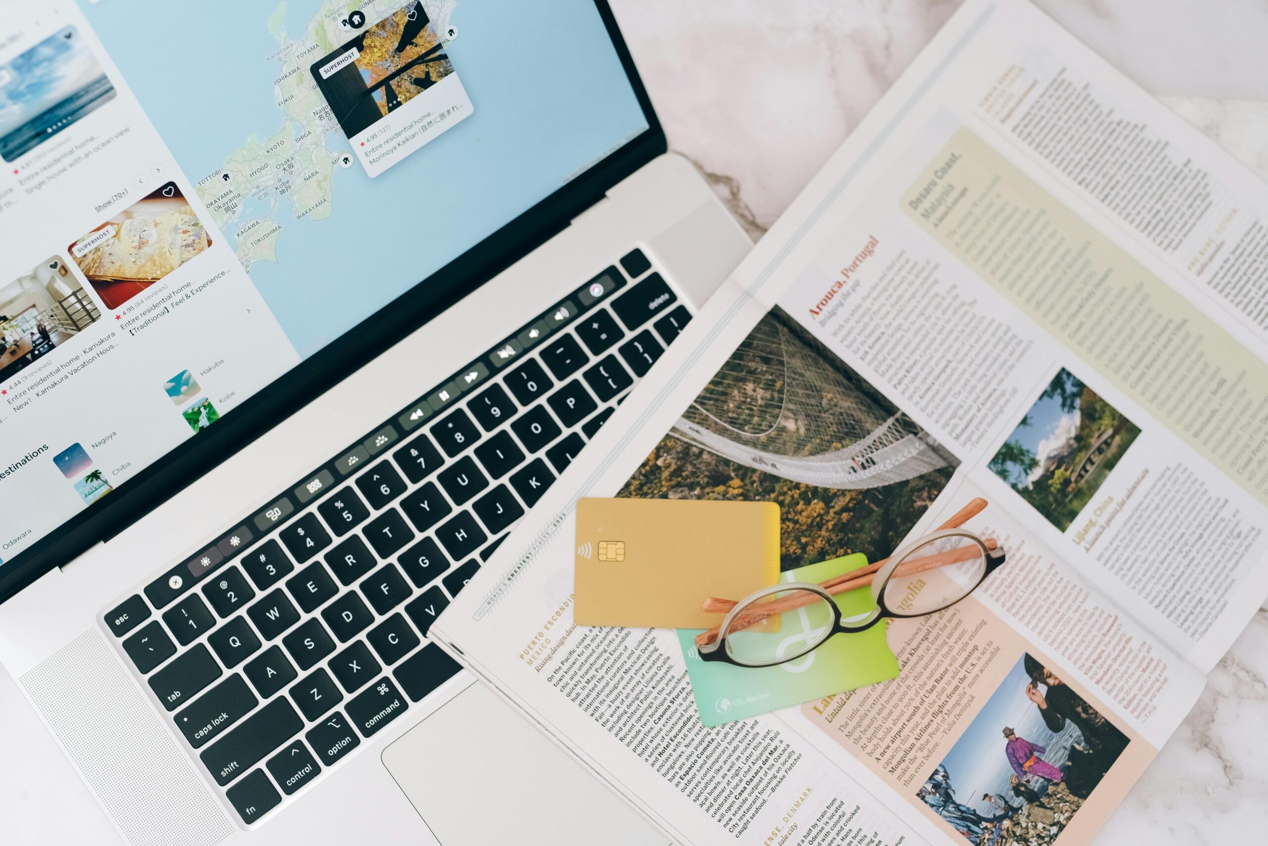 Magazine, Credit Cards, a Laptop and Eyeglasses on a Table